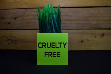 Acımasızlık Tahta arka planda izole edilmiş yapışkan bir nota bedavaya yaz.