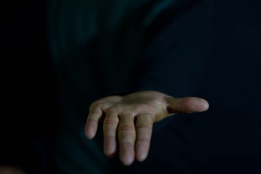 Siyah arka planda el ele tutuşmak anlamına geliyor. parmak üzerine seçici odaklanma