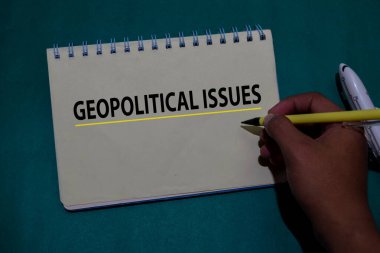 Geopolitical Issues write on a book isolated on Office Desk. clipart