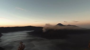 Bromo Dağı ve Bromo Ulusal Parkı 'ndaki vahşi ada üzerinde güzel renkli gündoğumu günbatımı
