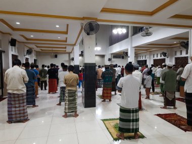 Müslümanlar, 22 Nisan 2020 'de, Endonezya, Bekasi' de sosyal uzaklık kavramı ile birlikte, Ramazan Kareem 'in önünde cemaatte dua ediyorlar.