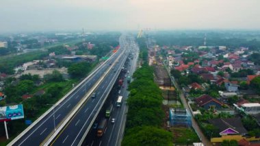 BEKASI, WESTJAVA, INDONESIA: MAYIS 12020: Yağmurdan sonra hareket eden arabalarla otoyolun çok katlı kavşak yolunun hava aracı görüntüsü. Arabalar bir yol kavşağında hareket ediyor.