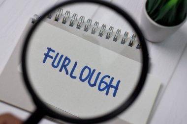Ofis masasında izole edilmiş büyüteçle yapışkan notlara izin yazısı