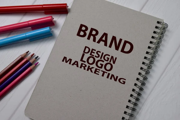 Brand, Design, Logo Marketing write on a book isolated on wooden table.