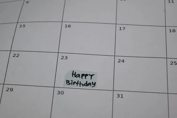 Happy Birthday text on monthly Calendar and marked 23th isolated on office desk