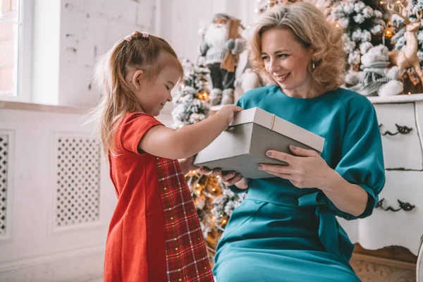 Presente de Natal surpresa - pequena menina e mulher na frente da árvore decorada — Fotografia de Stock