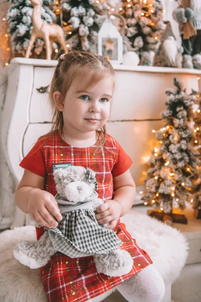 Menina pequena bonita com árvore de natal no fundo — Fotografia de Stock