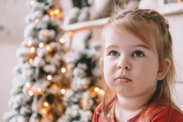 Hermosa niña con árbol de Navidad en el fondo — Foto de Stock