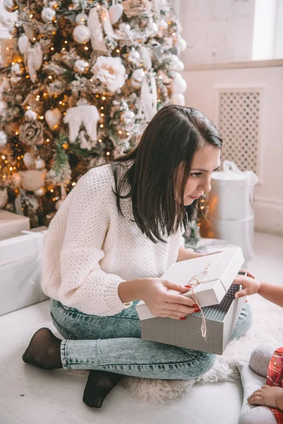 Surprise christmas present - little girl and woman in front of the decorated tree