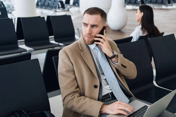 Man on smart phone - young business man in airport. Businessman using smartphone inside office building or airport.