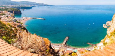 Yüksek uçurum manzarası, saf gök mavisi suyu, yüzen tekne ve gemileri, çakıl taşı plajları, Meta, Sant 'Agnello ve Napoli bölgesi yakınlarındaki Sorrento şehirlerinin kayalık çevresi.