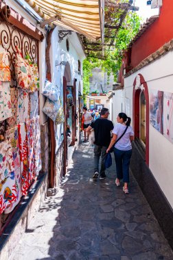 İnanılmaz bir ortaçağ Positano şehri kayalık arazide, insanlar ve turistler sanat galerileri, dükkanlar ve yerel işletmelerle dolu sıcak caddelerde yürüyor.