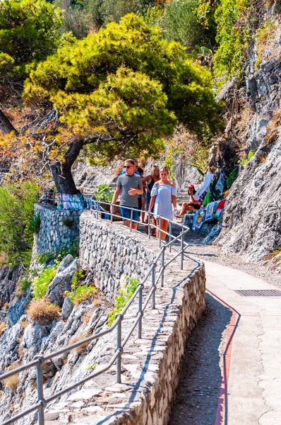 Paseo panorámico en el borde de la montaña rocosa y la bahía del mar Tirreno en Positano. Gente subiendo y bajando la colina . —  Fotos de Stock