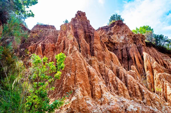 Grandes rocas de arcilla roja y acantilados bañados por las lluvias de invierno y los flujos de agua superficial. Cantera de arcilla, minas paisaje en el Parque Nacional en Campania, Italia —  Fotos de Stock