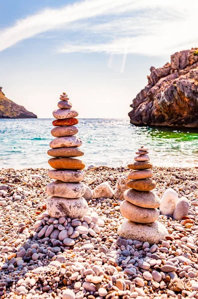 Дві вежі з плоских каменів на пляжі. Балансування каменю - це художня дисципліна, або хобі, в якій камені природно зрівноважуються один над одним в різних положеннях. Кала Б "янка Італія — стокове фото
