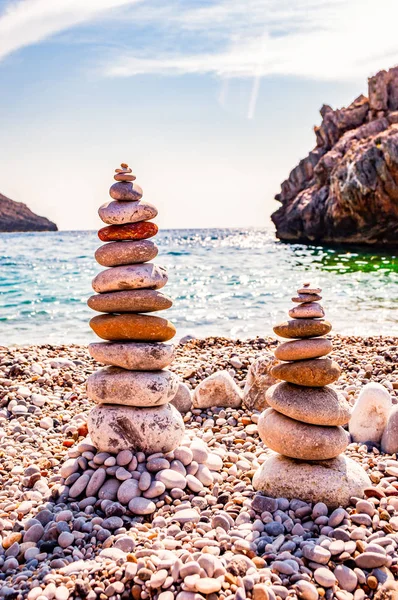 Two towers of flat stones on the beach. Stone balancing is the art discipline, or hobby in which rocks naturally balanced on top of one another in various positions. Cala Bianca Italy — Stock Photo, Image