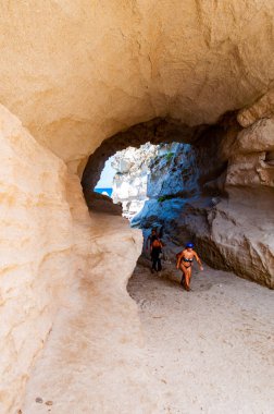 Ünlü Rotonda sahilindeki eşsiz deniz mağarasından inanılmaz deniz manzarası. Küçük plajda dinlenen turistler mağarada yürürler. Tyrhenian deniz manzarası.