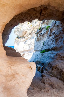 Tropea şehrindeki ünlü Rotonda plajı yakınlarındaki devasa kayadaki eşsiz deniz mağarasına açılan yuvarlak tünelin yan görüntüsü. Güney İtalya 'da Tyrhenian deniz kıyıları