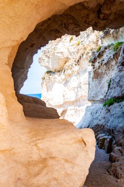 Tropea şehrindeki ünlü Rotonda plajı yakınlarındaki devasa kayadaki eşsiz deniz mağarasına açılan yuvarlak tünelin yan görüntüsü. Güney İtalya 'da Tyrhenian deniz kıyıları