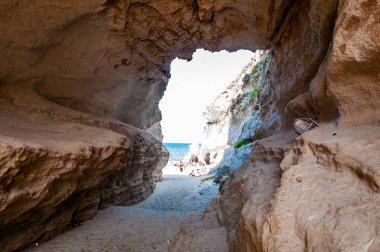 Ünlü Rotonda sahilindeki eşsiz deniz mağarasından inanılmaz deniz manzarası. Küçük plajda dinlenen turistler mağarada yürürler. Tyrhenian deniz manzarası.
