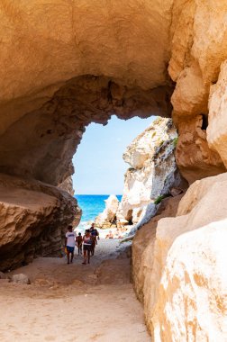 Ünlü Rotonda sahilindeki eşsiz deniz mağarasından inanılmaz deniz manzarası. Küçük plajda dinlenen turistler mağarada yürürler. Tyrhenian deniz manzarası.