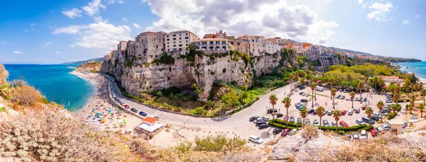 Panorama da paisagem urbana de Tropea com falésias altas com edifícios e apartamentos construídos no topo da cidade, praia de Rotonda cheia de pessoas, ruas e passeio marítimo — Fotografia de Stock