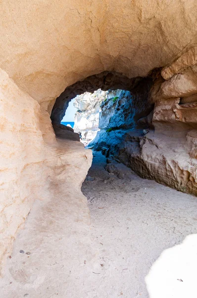 Vista lateral en el túnel de entrada redonda a la cueva marina única en roca masiva en la ciudad de Tropea cerca de la famosa playa de Rotonda. Orilla del mar Tirreno en el sur de Italia —  Fotos de Stock
