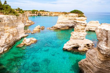 Torre Sant Andrea plajı yumuşak nasırlı kayaları ve uçurumları, deniz yığınları, küçük koyları ve pürüzlü kıyı manzarasıyla. Kristal berrak su şeklindeki beyaz taş doğal yığınlar oluşturur. Melendugno İtalya