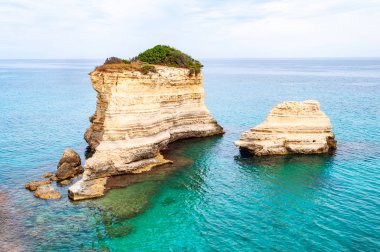 Torre Sant Andrea plajı yumuşak nasırlı kayaları ve uçurumları, deniz yığınları, küçük koyları ve pürüzlü kıyı manzarasıyla. Kristal berrak su şeklindeki beyaz taş doğal yığınlar oluşturur. Melendugno İtalya