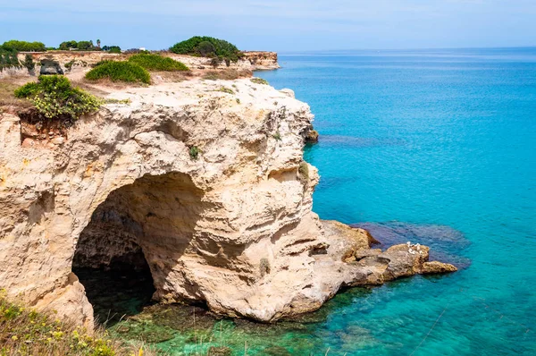 Παραλία Torre Sant Andrea με τα μαλακά ασβεστολιθικά βράχια και γκρεμούς, τις θαλάσσιες στοίβες, τους μικρούς όρμους και το ακανόνιστο παραθαλάσσιο τοπίο. Κρύσταλλο καθαρό νερό σχήμα λευκή πέτρα δημιουργώντας φυσικά τόξα. Melendogno Ιταλία — Φωτογραφία Αρχείου