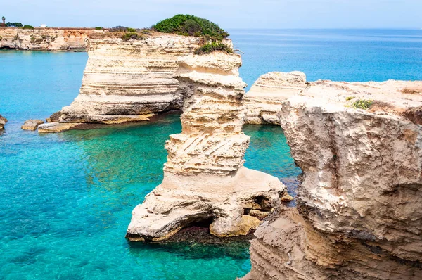 Playa Torre Sant Andrea con sus suaves rocas calcáreas y acantilados, pilas de mar, pequeñas calas y el paisaje irregular de la costa. Forma de agua cristalina piedra blanca crear pilas naturales. Melendugno Italia — Foto de Stock