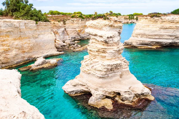 Torre Sant Andrea plajı yumuşak nasırlı kayaları ve uçurumları, deniz yığınları, küçük koyları ve pürüzlü kıyı manzarasıyla. Kristal berrak su şeklindeki beyaz taş doğal yığınlar oluşturur. Melendugno İtalya — Stok fotoğraf