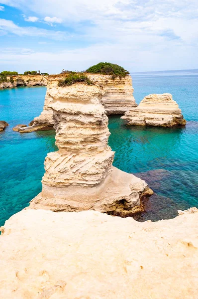 Playa Torre Sant Andrea con sus suaves rocas calcáreas y acantilados, pilas de mar, pequeñas calas y el paisaje irregular de la costa. Forma de agua cristalina piedra blanca crear pilas naturales. Melendugno Italia — Foto de Stock