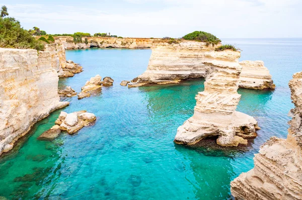 Playa Torre Sant Andrea con sus suaves rocas calcáreas y acantilados, pilas de mar, pequeñas calas y el paisaje irregular de la costa. Forma de agua cristalina piedra blanca crear pilas naturales. Melendugno Italia — Foto de Stock