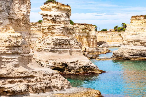 Playa Torre Sant Andrea con sus suaves rocas calcáreas y acantilados, pilas de mar, pequeñas calas y el paisaje irregular de la costa. Forma de agua cristalina piedra blanca creando arcos naturales. Melendugno Italia — Foto de Stock