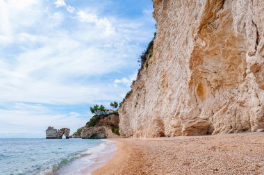 Gargano Ulusal Parkı 'ndaki Baia delle Zagare Körfezi' nin ünlü deniz yığınları. Adriyatik deniz dalgaları, rüzgar ve erozyon tarafından yapılan doğal kaya heykelleri kayalık sahilin yakınındaki denize yığıldı.