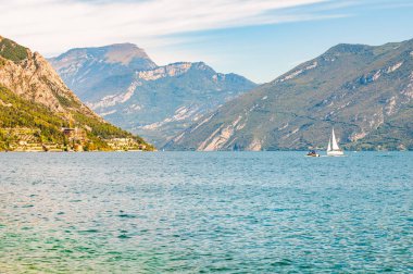 İtalya 'daki güzel Garda Gölü yüksek dolomit dağlarıyla çevrili. Gölde yüzen klasik beyaz yelkenli yat. Gölün kayalık kıyılarına çeşitli oteller ve özel evler inşa edildi.