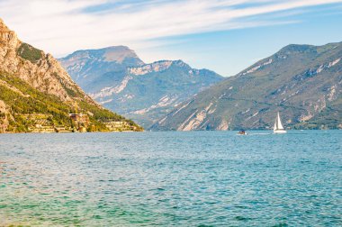 İtalya 'daki güzel Garda Gölü yüksek dolomit dağlarıyla çevrili. Gölde yüzen klasik beyaz yelkenli yat. Gölün kayalık kıyılarına çeşitli oteller ve özel evler inşa edildi.