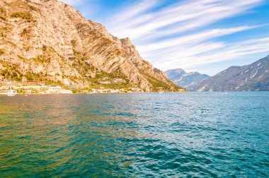 Lombardy, İtalya 'daki inanılmaz Garda Gölü yüksek dolomit dağlarıyla çevrili. Tekneler ve yatlar gölde yüzüyor. Gölün kayalık kıyılarına çeşitli oteller ve özel evler inşa edildi.