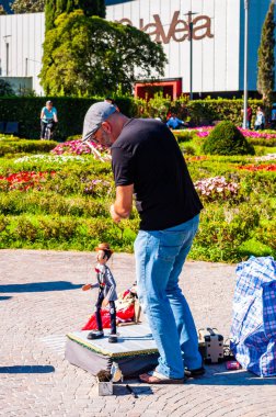 Sanatçı kuklacı oyuncağıyla Riva del Garda şehrindeki Garda Gölü 'nde gösteri yapıyor.