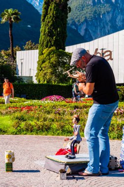 Sanatçı kuklacı oyuncağıyla Riva del Garda şehrindeki Garda Gölü 'nde gösteri yapıyor.
