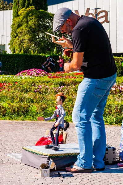 Sanatçı kuklacı oyuncağıyla Riva del Garda şehrindeki Garda Gölü 'nde gösteri yapıyor.