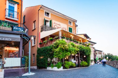 Lombardy, İtalya 'daki Sirmione Eski Kasabası' nın merkezinde yeşil üzüm terası ile kaplı rahat bir restoran.