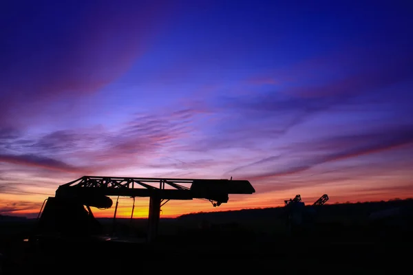 Niesamowity Bardzo Kolorowy Zachód Słońca Wsi Sylwetka Przemysłowej Maszyny Rolniczej — Zdjęcie stockowe
