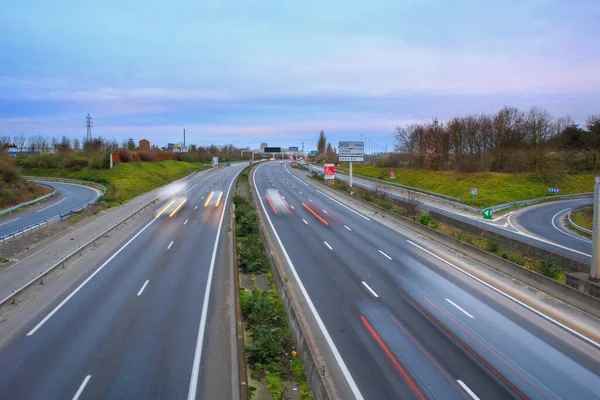 Spind by cars and trucks driving on a fast lane. Vehicles on the highway. Transport photographed in long exposure mode in lightpainting.