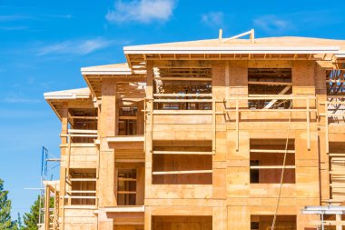Mavi gökyüzü arka plan güneşli bir günde yapım aşamasında yeni apartman.