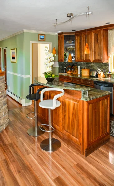 Elegante cocina interior de madera con mesa de la isla y dos sillas en frente . —  Fotos de Stock