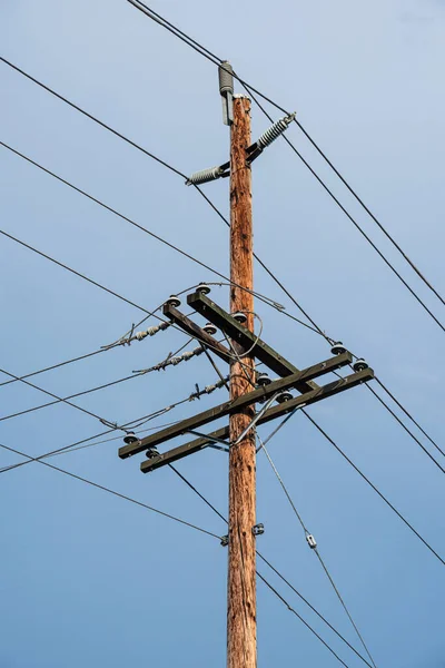 Електричний стовп і дроти, дерев'яний електричний стовп на фоні блакитного неба . — стокове фото