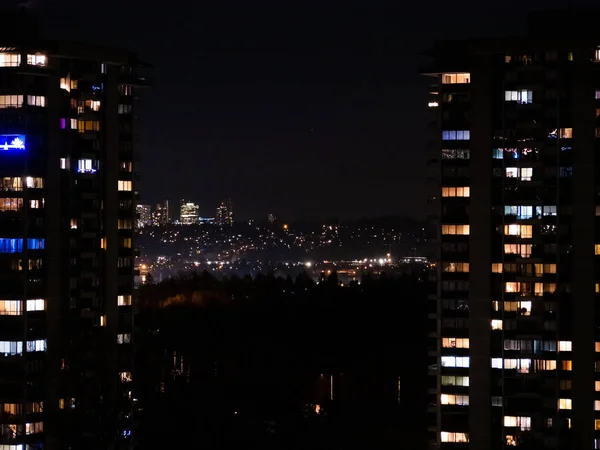 Nattutsikt över staden. Belysta fönster i höghusbyggnader — Stockfoto