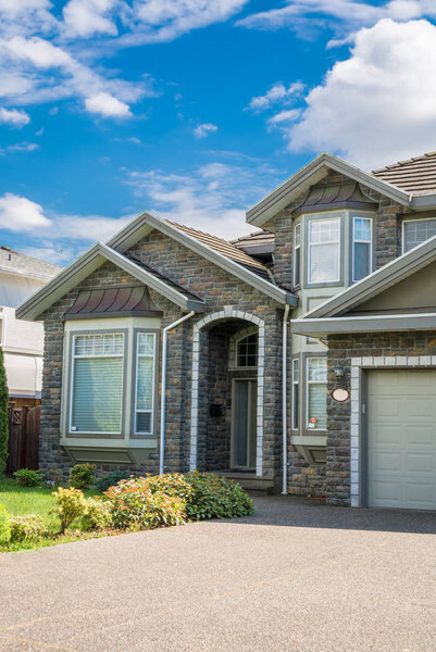 Entrance of modern luxury residential house on cloudy sky background